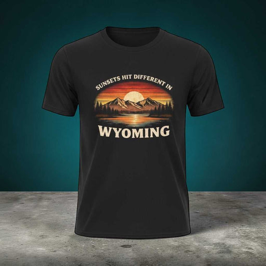 Wyoming Sunset Graphic T-Shirt by Big Sky Ranch Co. featuring mountain and sunset design with "Sunsets Hit Different in Wyoming" text.